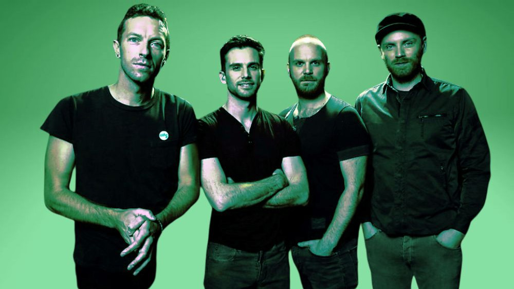 The 4 band members of Coldplay standing in a line looking at the camera with a garduated green background behind them. The image has a duotone green cast.